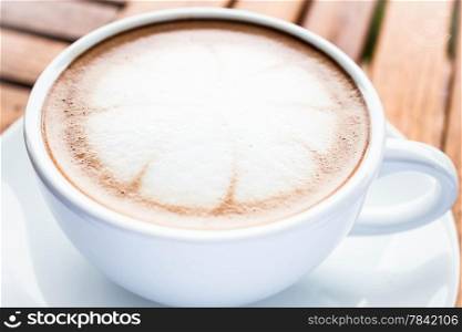 Serving cup of hot cafe mocha on wooden table