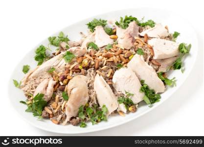 Serving dish of Lebanese chicken and spiced rice with meat, roast nuts and a parsley garnish, a speciality for celebrations in the Levant