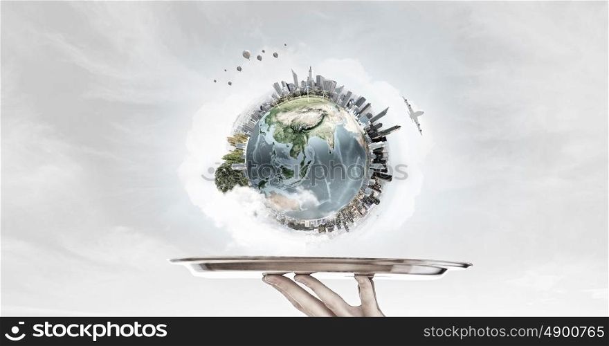 Serving Earth planet. Hand of waiter holding tray with Earth planet. Elements of this image are furnished by NASA