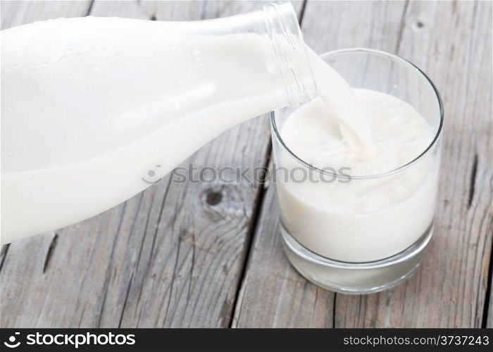 Serving fresh milk in a glass vase on a wooden table