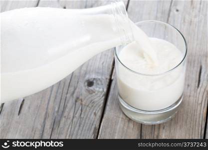 Serving fresh milk in a glass vase on a wooden table