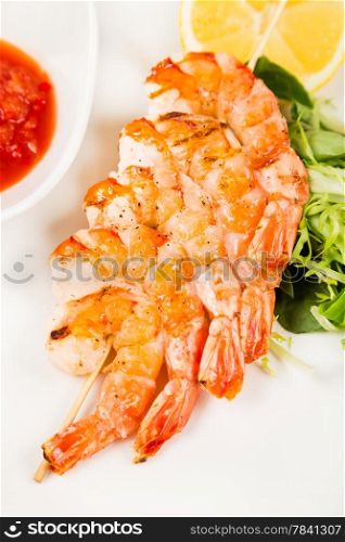 serving hot shrimps on skewer with red sauce