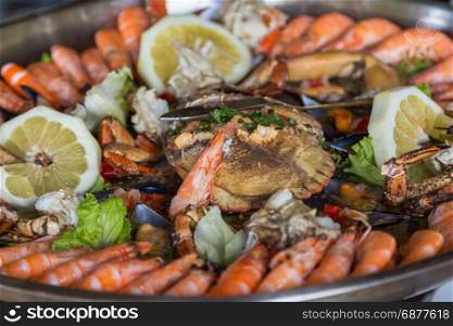 serving plate seafood and crab in big metal dish on table