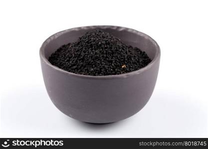 Sesame black seeds in stone bowl isolated on white background