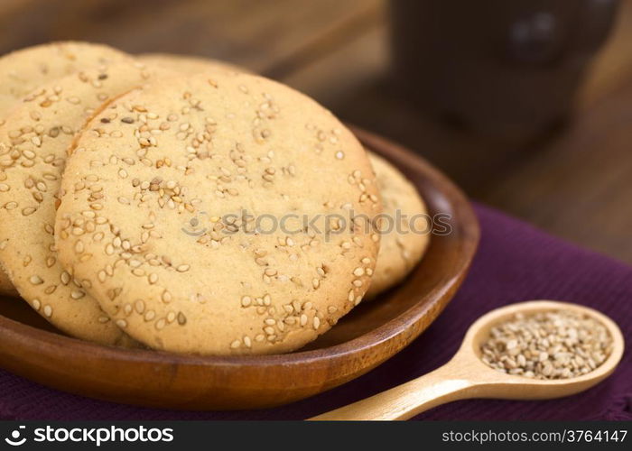 Sesame cookies on wooden plate (Selective Focus, Focus one third into the first cookie)