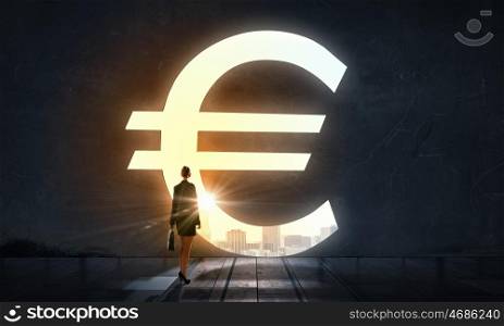Set big financial goals. Silhouette of businesswoman in light of big euro symbol