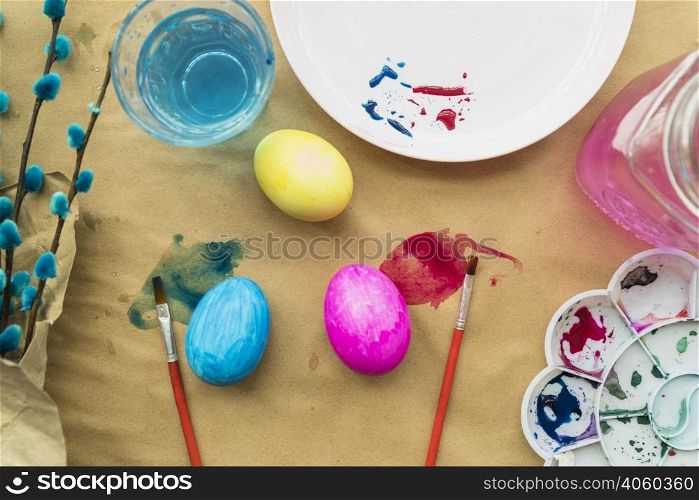 set easter eggs near willow twigs brushes