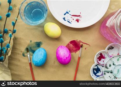 set easter eggs near willow twigs brushes