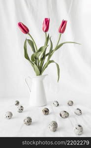 set easter quail eggs near flowers vase