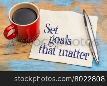 Set goals that matter advice or reminder - handwriting on a napkin with cup of coffee against gray slate stone background