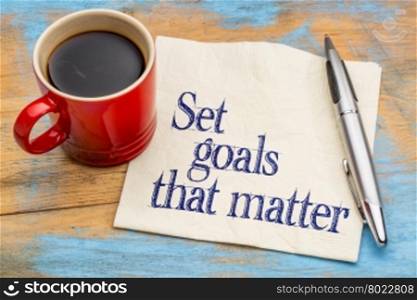 Set goals that matter advice or reminder - handwriting on a napkin with cup of coffee against gray slate stone background