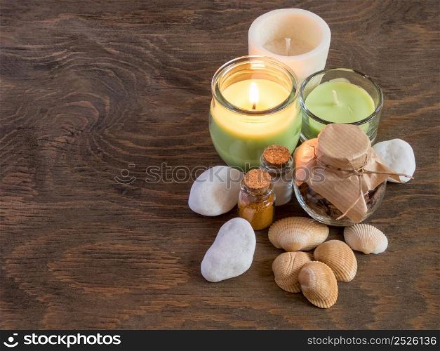 set ingredients and spice for aromatherapy and body care on wooden surface. burning candle flame. top view. SPA still life. the attributes of aromatherapy
