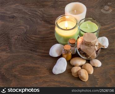 set ingredients and spice for aromatherapy and body care on wooden surface. burning candle flame. top view. SPA still life. the attributes of aromatherapy