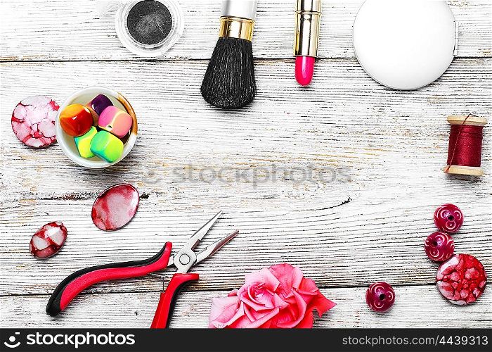 Set of accessories for needlework of pliers,beads and jewelry and cosmetics on the background