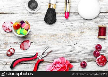 Set of accessories for needlework of pliers,beads and jewelry and cosmetics on the background