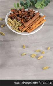 Set of aromatic spices, cinnamon, cardamom, star anise over light kitchen countertop
