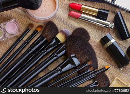Set of  black professional brushes, lipsticks, eye shadows and  powder, top view . frame of make up 