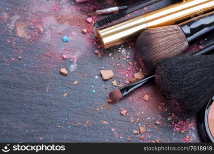 set of brushes and maskara on black background. brushes on eye shadows palette