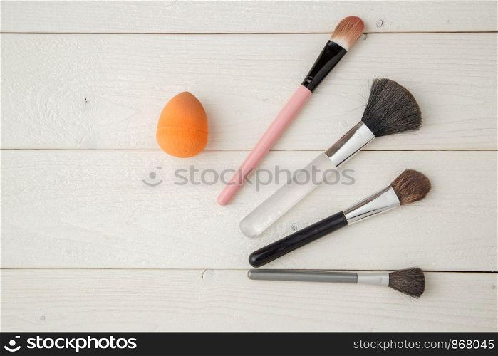 set of brushes for a make-up on a light wooden background. Flat Lay