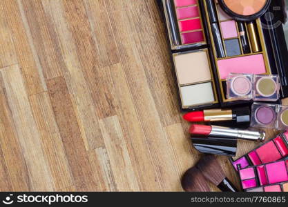 set of brushes, lipsticks, maskara, eye shadows with copy space on wooden table desktop. set of make up