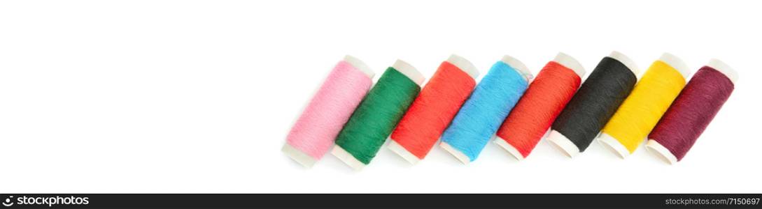 Set of colored thread coils isolated on white background, sewing and tailoring. Free space for text. Wide photo .