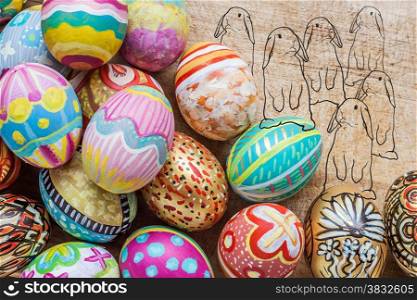 Set of colorful easter egg on wooden background with drawing of rabbit