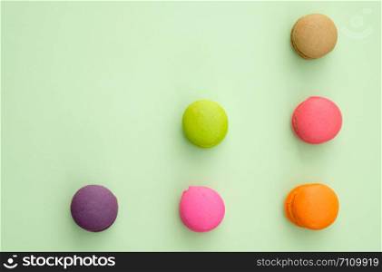 Set of different colorful macaroons on green background. Sweet and tasty for cooking and restaurant menu.