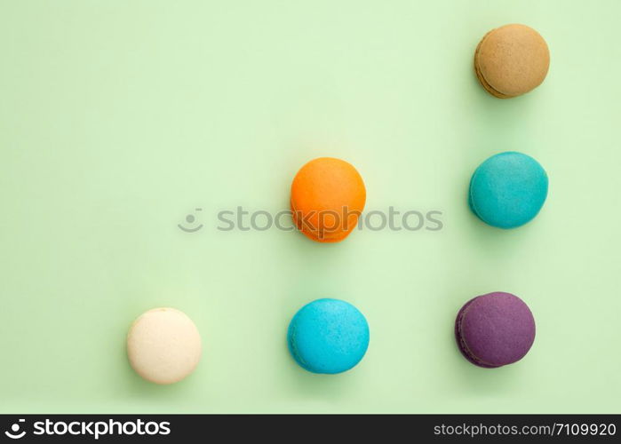 Set of different colorful macaroons on green background. Sweet and tasty for cooking and restaurant menu.