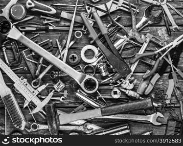 Set of different tools on wooden background, bw photo