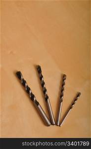 set of drill bits on wooden background (shallow depth of field)