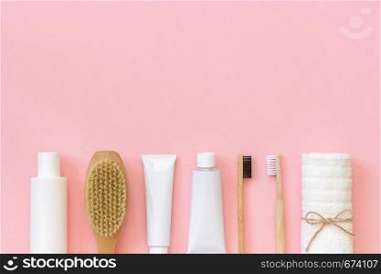 Set of eco cosmetics products and tools for shower or bath Bamboo toothbrush, natural brush, white bottles, towel accessories for body, face and teeth care on pink background. Copy space, Top view.. Set of eco cosmetics products and tools for shower or bath Bamboo toothbrush, natural brush, white bottles, towel accessories for body, face and teeth care on pink background. Copy space, Top view