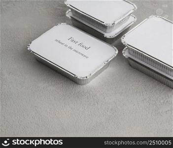set of fast food in a box of foil on a gray rough background. food for businessman and busy people. fast food set