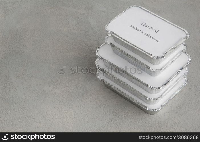 set of fast food in a box of foil on a gray rough background. food for businessman and busy people. fast food set