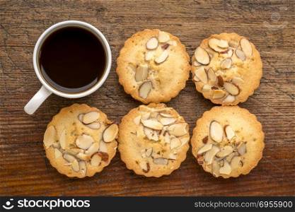 set of French almond cookies and espresso coffee against weathered wood background