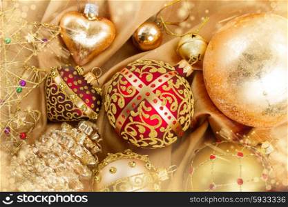 set of golden christmas balls decoration on soft silk background with sparkles. golden christmas ball