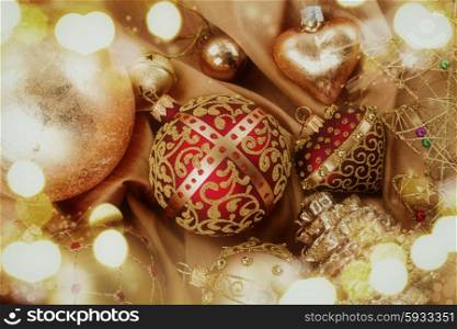 set of golden christmas balls decoration on soft silk background with sparkles, retro toned