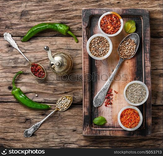 set of Indian spices peppers. peppercorns in spoon and the mortar on retro wooden background