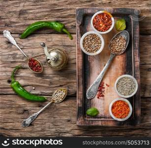 set of Indian spices peppers. peppercorns in spoon and the mortar on retro wooden background
