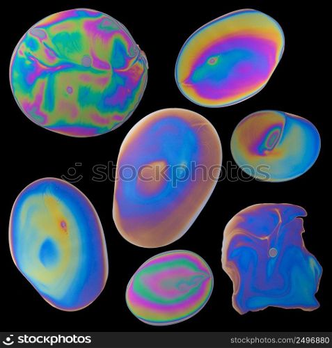 Set of iridescent oil drops spills isolated on black background