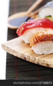 set of japanese sushi with chopsticks and soy sause over white