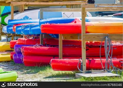 set of kayaks laying on sandy beach on sunny day