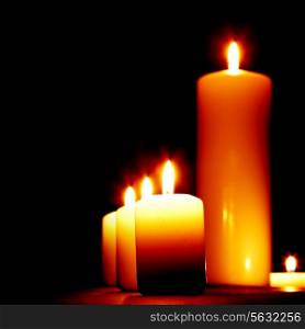 Set of lighting candles in a row on dark background