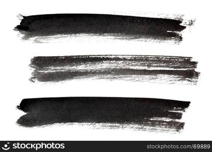Set of long ink black brush strokes isolated on the white background