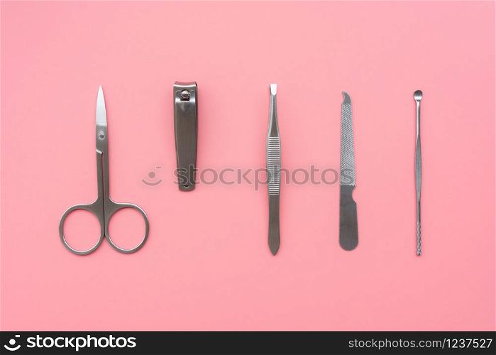 Set of manicure instruments and tools on pink background, top view