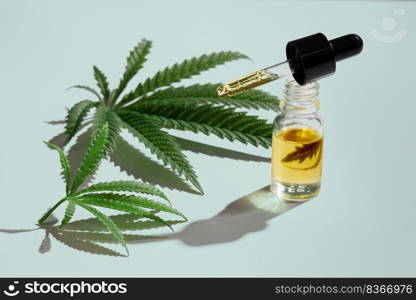 Set of marijuana features with CBD oil product on glass bottle with dropper lid, hemp leaf and dry bud, hemp leaf and bud arranged on empty background. Cannabis product concept.. Set of legalized marijuana features with CBD oil product, hemp leaf and bud.