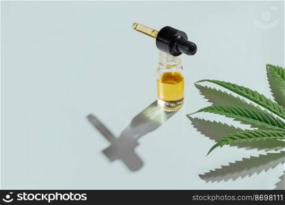 Set of marijuana features with CBD oil product on glass bottle with dropper lid, hemp leaf and dry bud, hemp leaf and bud arranged on empty background. Cannabis product concept.. Set of legalized marijuana features with CBD oil product, hemp leaf and bud.