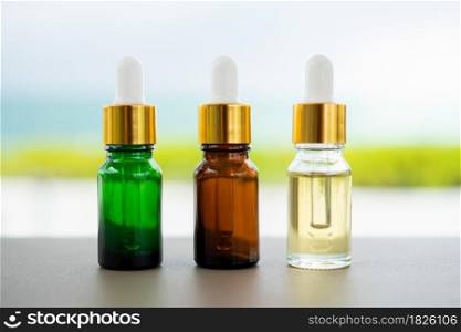 Set of multi color glass bottles with dropper on the table. Concept of aroma oil, cosmetic and beauty skin.