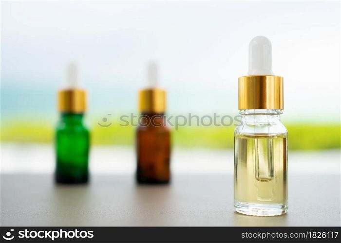 Set of multi color glass bottles with dropper on the table. Concept of aroma oil, cosmetic and beauty skin.