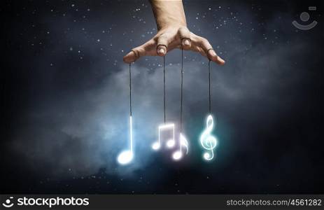 Set of music icons. Close up of human hand and items hanging on fingers