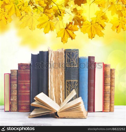 set of old books with open one on white wooden background. set of books